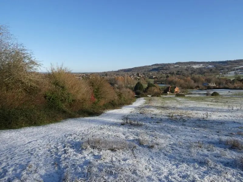 Frosty Cotswold Way path approaching Broadway with rolling fields on either side